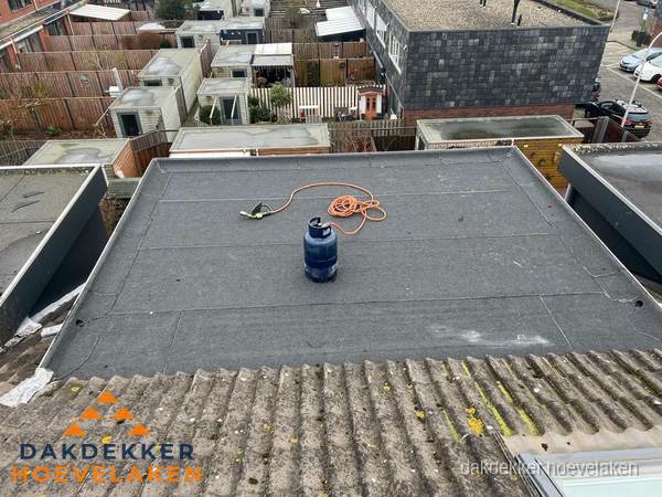 Plat dak met nieuwe bitumen dakbedekking en brandgereedschap in Hoevelaken