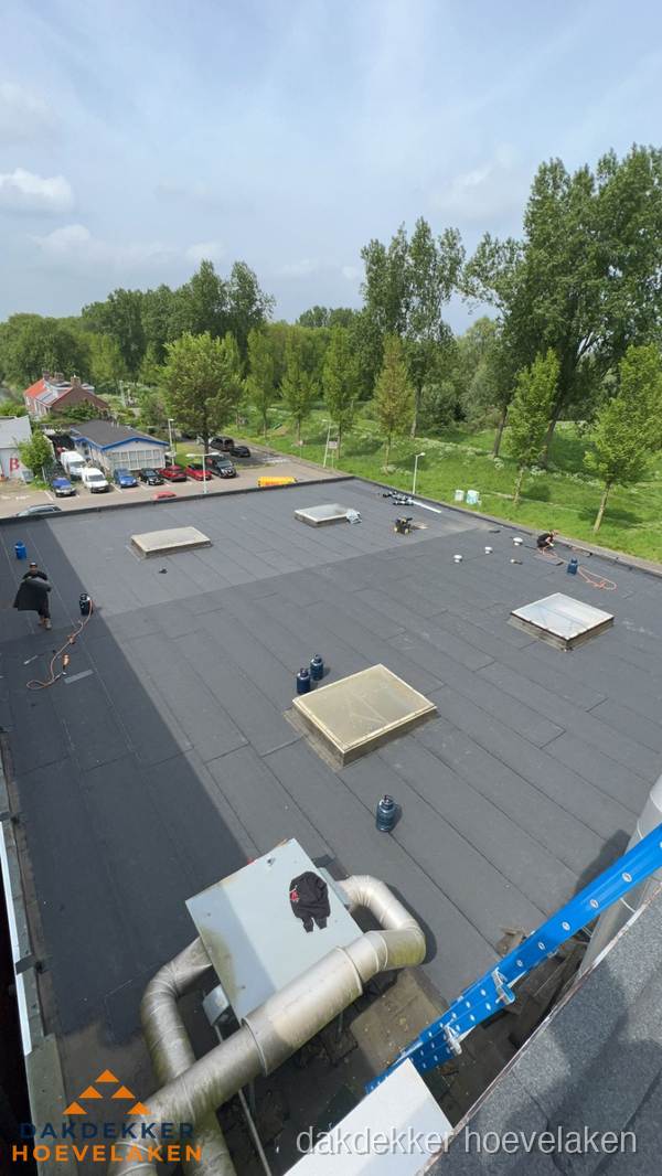 Dakdekker aan het werk op groot plat dak met bitumen in Hoevelaken Dakdekker aan het werk op groot plat dak met bitumen in Hoevelaken