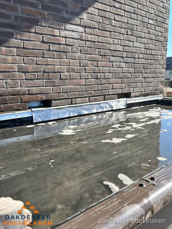Stilstaand water op plat dak door slechte afwatering in Hoevelaken Stilstaand water op plat dak door slechte afwatering in Hoevelaken