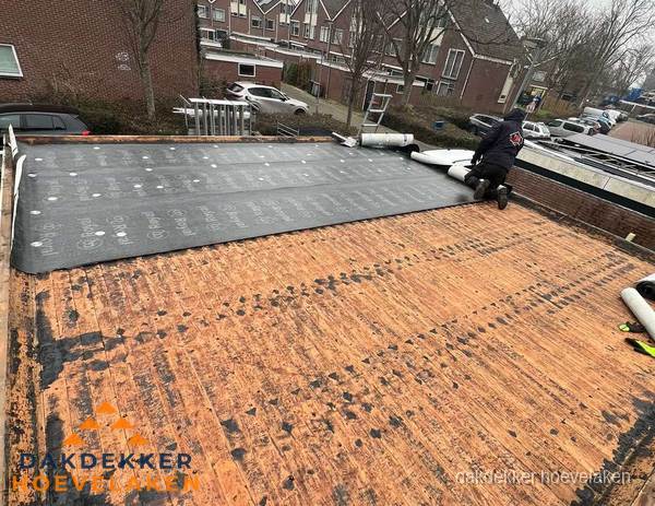 Dakdekker legt onderlaag op plat dak met houten constructie in Hoevelaken